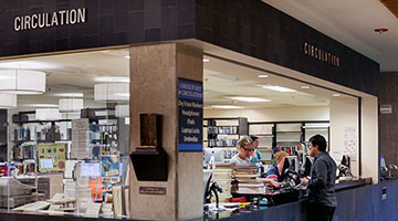 circulation desk stacked with books